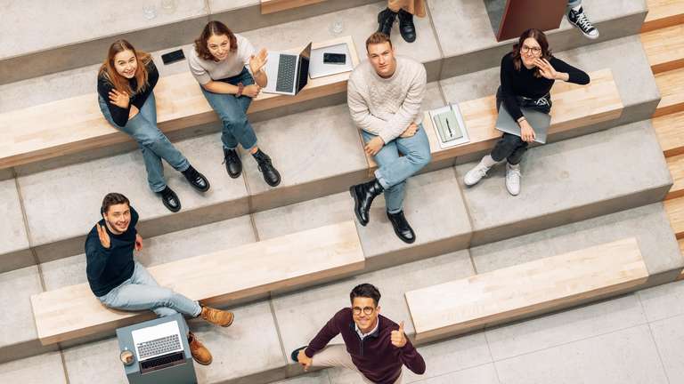 Studentin spricht per Videocall mit einer Collegeberaterin und macht sich Notizen
