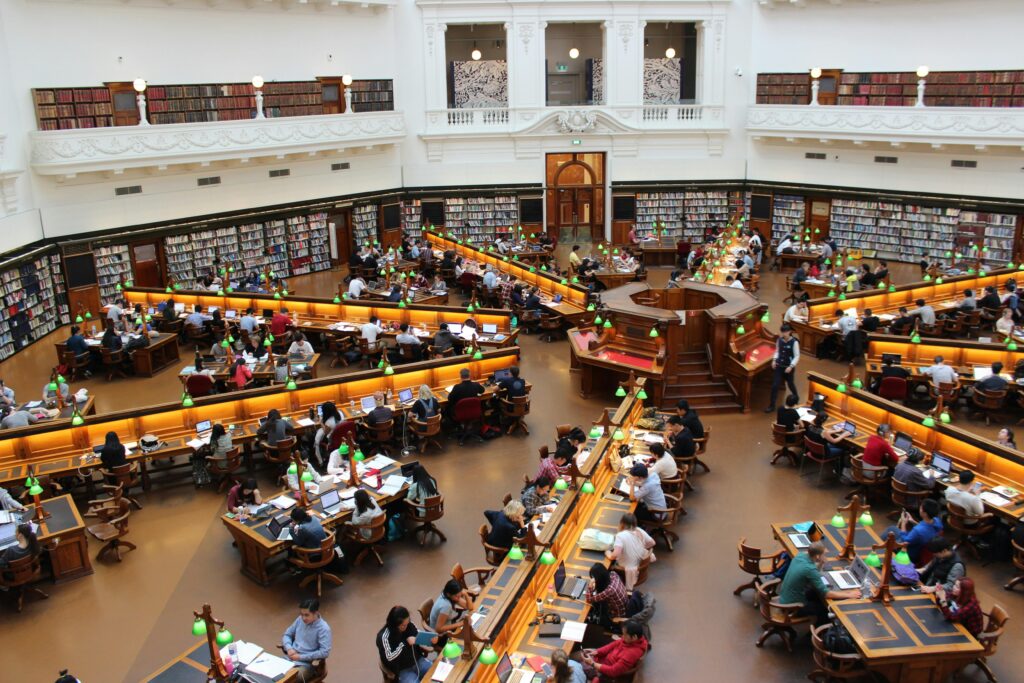 Große Bücherei einer Ivy League Universität in Sternform angerichtet. Es sitzen ein paar Duzend Studierende und lernen.