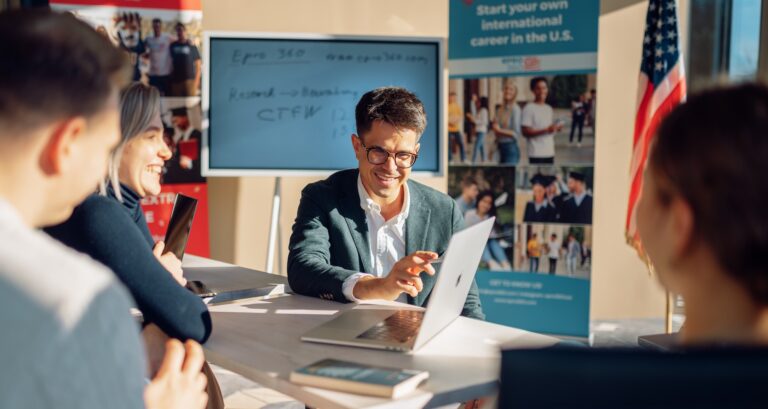 Studienberater bespricht gemeinsam mit angehenden Studierenden die Strategie für Bewerbungen an amerikanischen Universitäten während einer persönlichen Beratungssitzung.